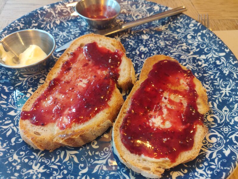Pan de campaña con mantequilla y mermelada de frambuesa